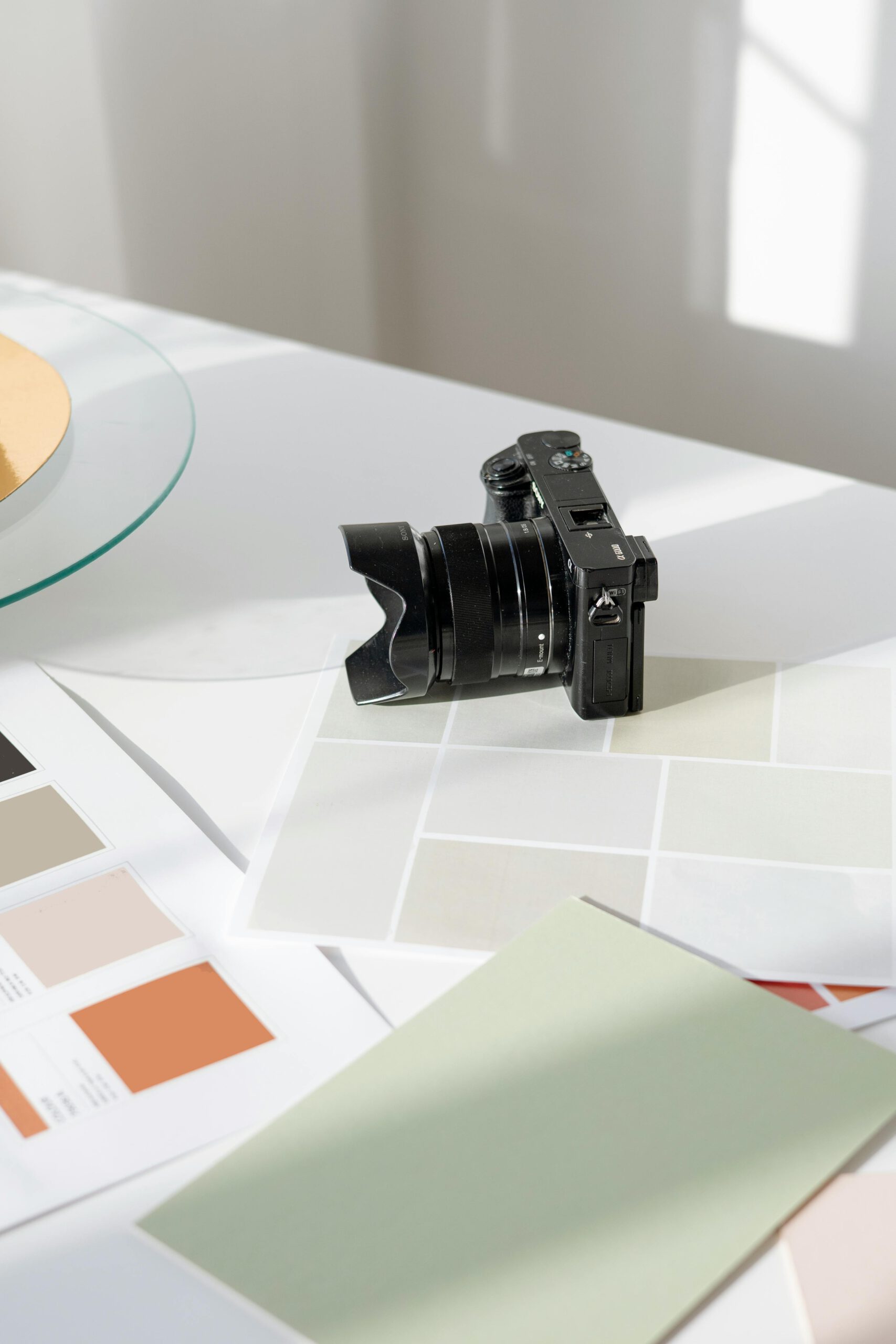 Digitalkamera liegt auf einem Tisch mit Farbmustern und Designvorlagen